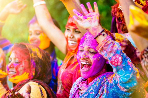 Indian women throwing colored Holi powder