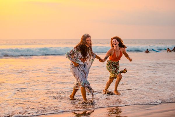 two women on beach in bali at sunset