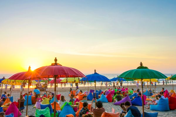 Colourful beach umbrellas and beanbags on a beach at sunset