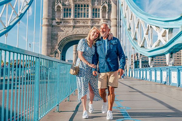 Couple walking arm in arm along London Bridge