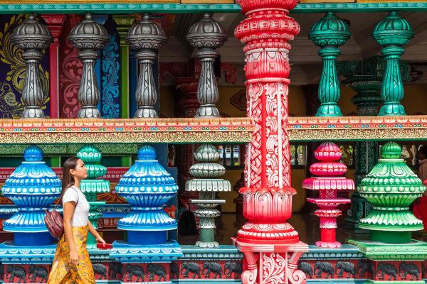 Lady walking alongside road with colourful objects behind her