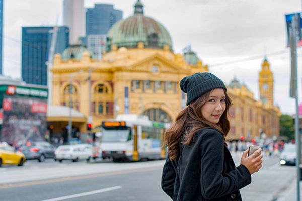 Woman smiling with Flinders Street Train Station in the background