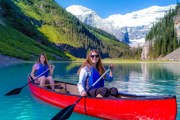 Female couple sitting in a red kayak on a lake