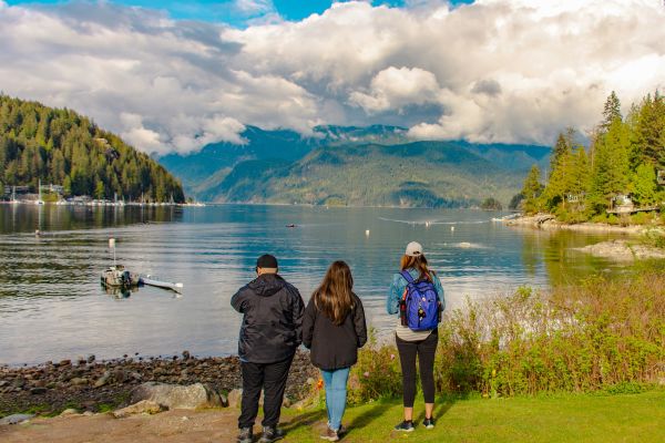 People looking out at a lake and rolling hills on a cloudy day