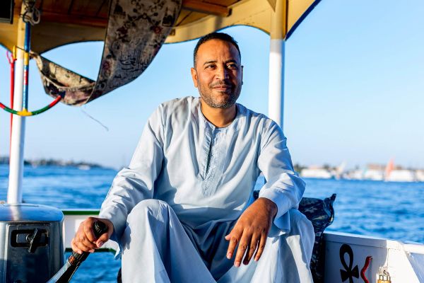 Man driving boat along river