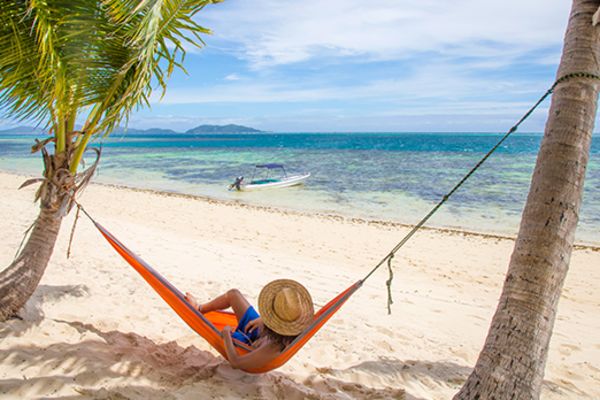 Person relaxing in a hammock on a beach