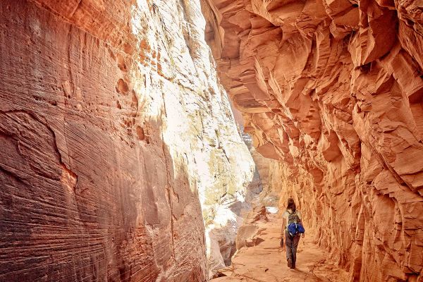 Wide shot of a woman walking through a rocky chasm