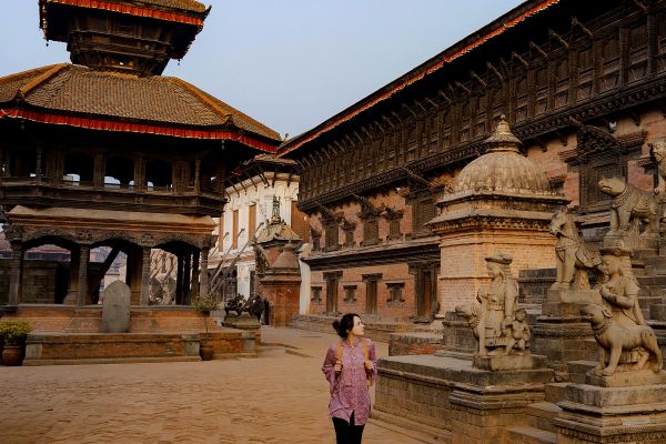 Female backpacker walking through a temple in Nepal
