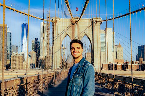 Man smiling on the Brooklyn Bridge
