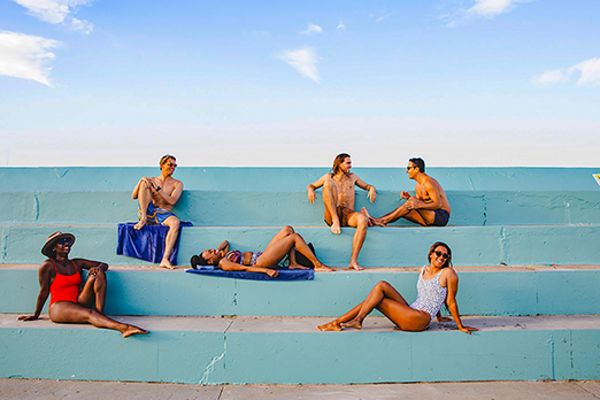 People in swimsuits lounging on blue steps