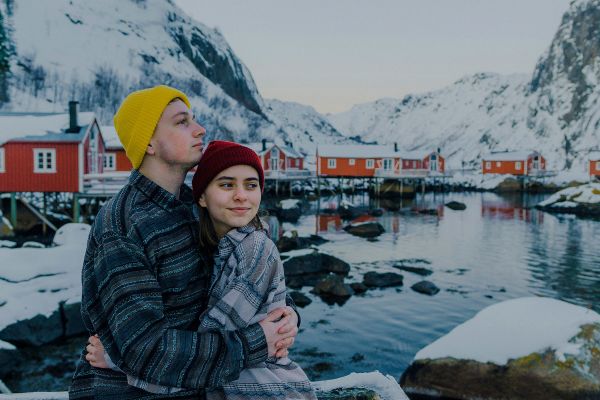 Couple hugging in a cold coastal town covered in snow