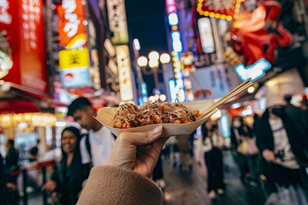 closeup of Takoyaki (octopus balls) in a busy shopping street in Osaka