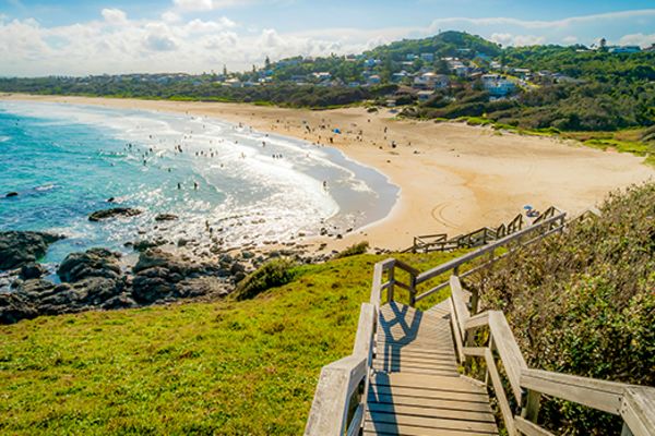 Wide shot of a wooden staircase leading to a beach