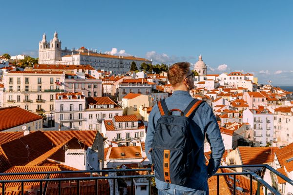Man with a backpack looking out over the city of Portugal
