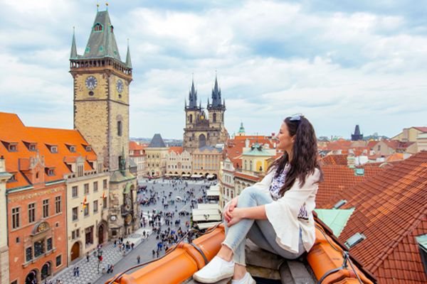 woman sitting on roof of house in prague