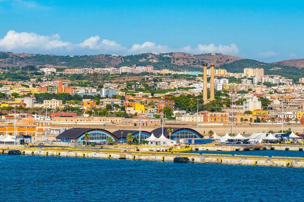 Old bridge in Rome with buildings and mountains in the background