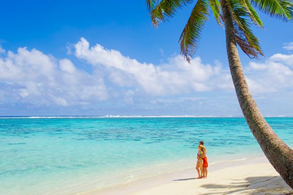 lady on beach under tree in rarotonga