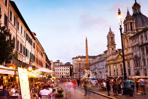 Three friends sharing pizza in a cobblestone street