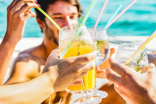 Friends cheering with drinks on the beach