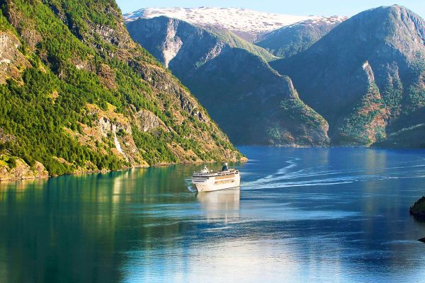 Woman pushing a bike past colourful, tightly-packed buildings in Scandinavia