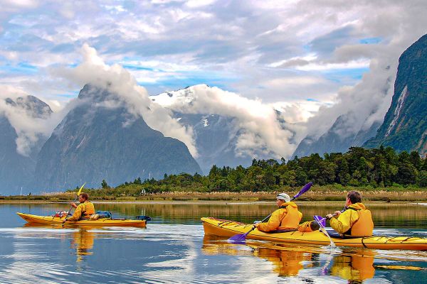 People in yellow canoes rowing down a wide river