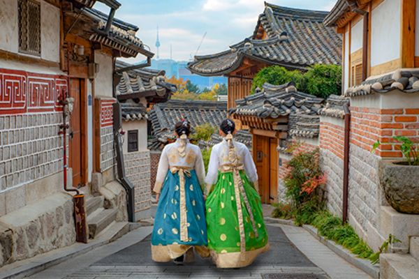 two women in hanboks walking down street in seoul
