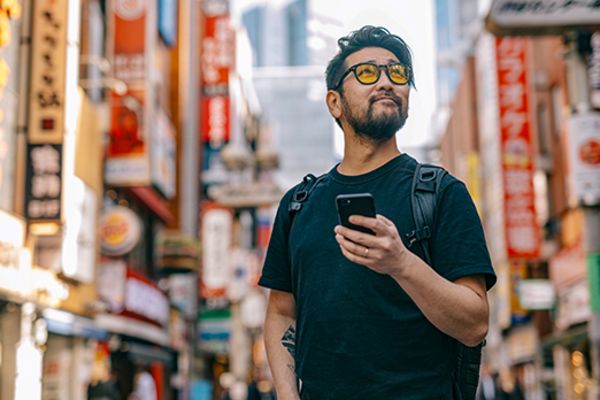 man holding phone on street in shinjuku