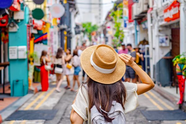 woman with hat walking down road in singapore