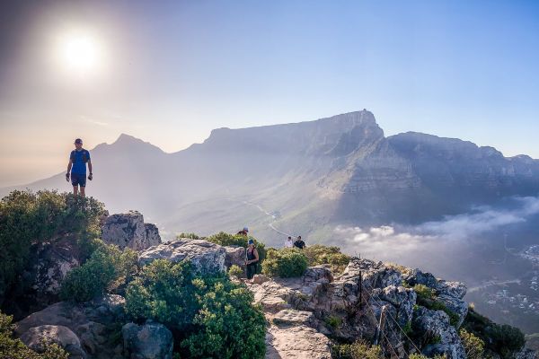 People hiking on steep mountains under a bright sun