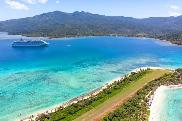 Woman eating fruit in front of overwater bungalows