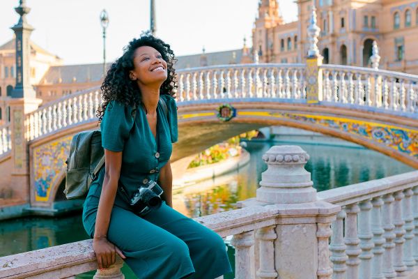 Woman sitting on a bridge with the Plaza de España in the background
