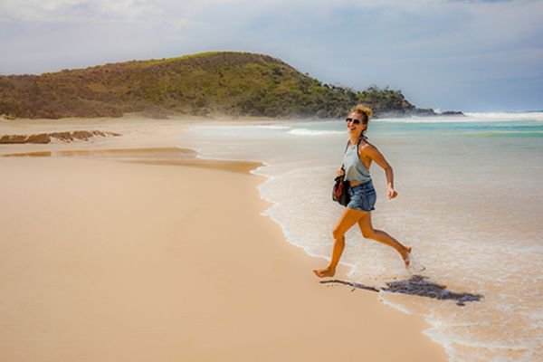 Woman laughing running out of the surf at the beach
