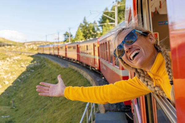 Woman in yellow reaching out of a red train
