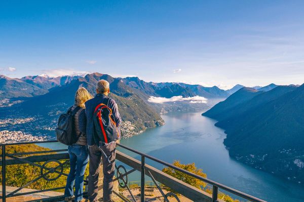 Elderly couple at a lookout overlooking a fjord cutting through tall mountains