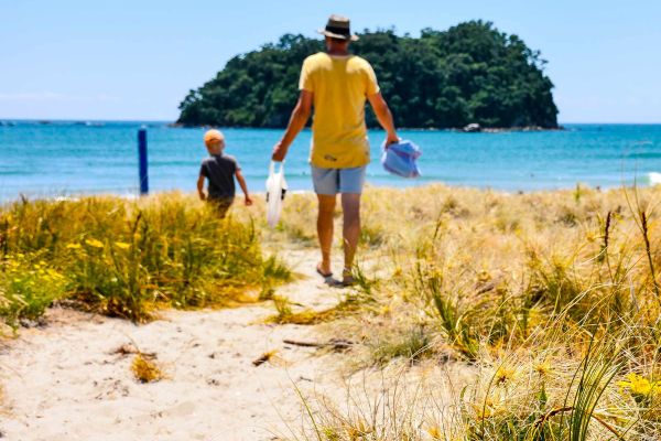 Father and son walking down pathway to beach