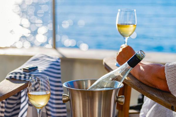 Bottle of wine on a table with ocean in the background
