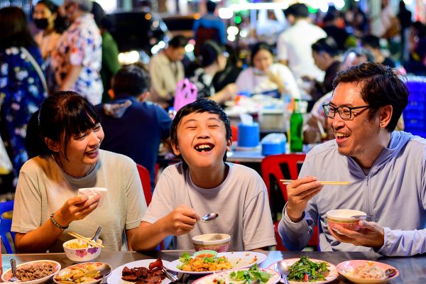 Family eating dinner in a busy shopping street