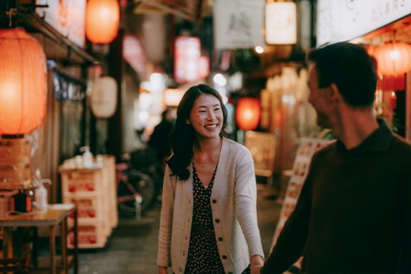 Couple walking down a street lit by lanterns in Tokyo
