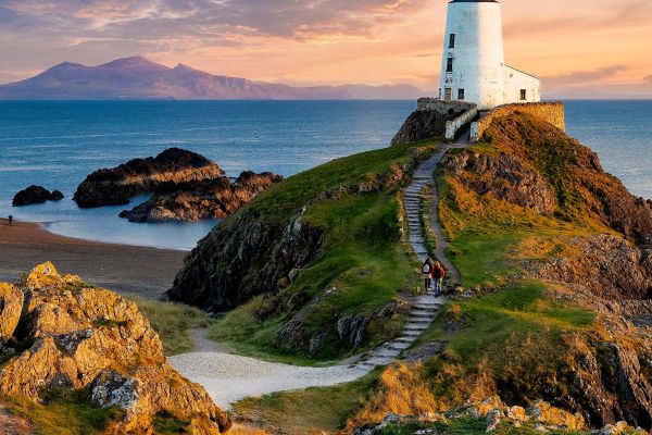 Large white lighthouse on a cliff in the early evening