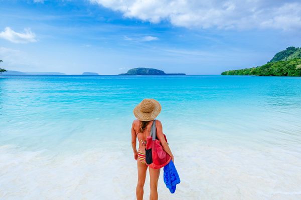 Lady holding flippers looking out to the ocean