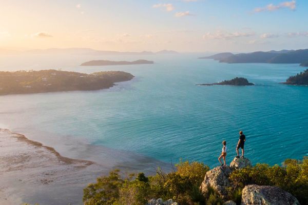 Couple on a lookout pointing at a sandbank out at sea