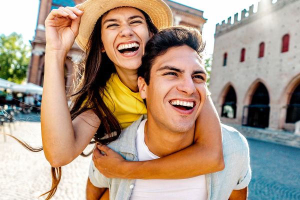 Couple laughing walking through a cobblestone gathering area