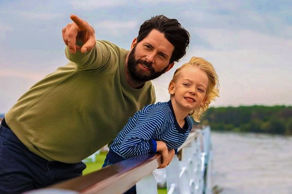 Father and child sightseeing from the top deck