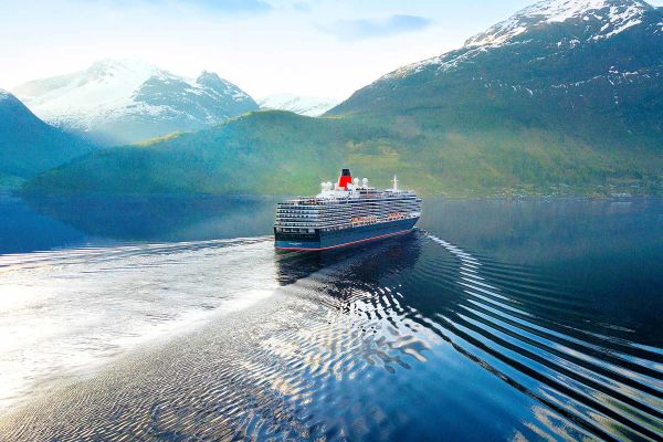 Cruise ship with snow-capped mountain in the distance