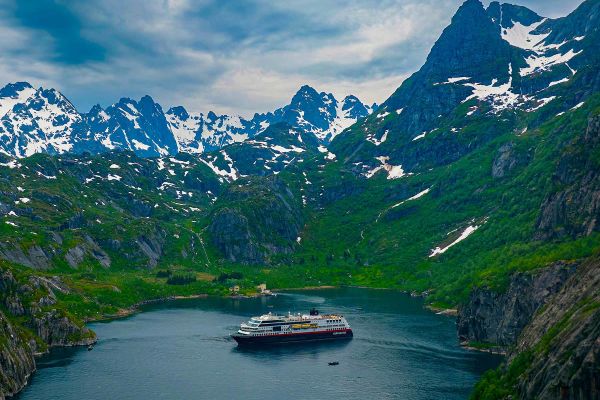 Cruise ship with snowy mountains in the distance