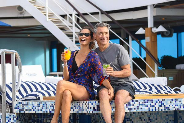 Couple enjoying cocktails poolside
