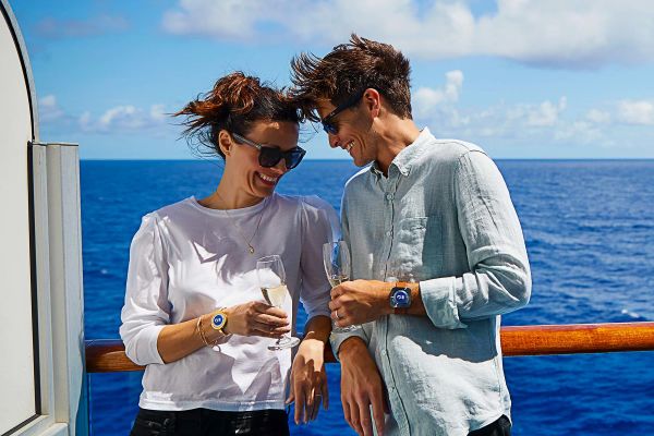 Couple enjoying a drink along balcony railing