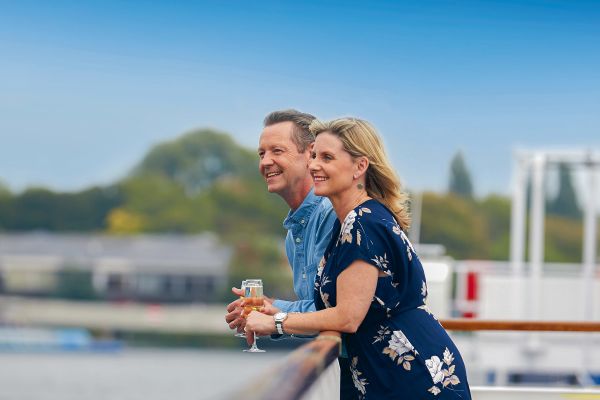 Couple enjoying champagne on the edge of a cruise ship