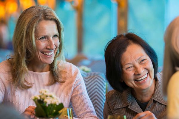 Closeup of women smiling at dinner on a cruise ship