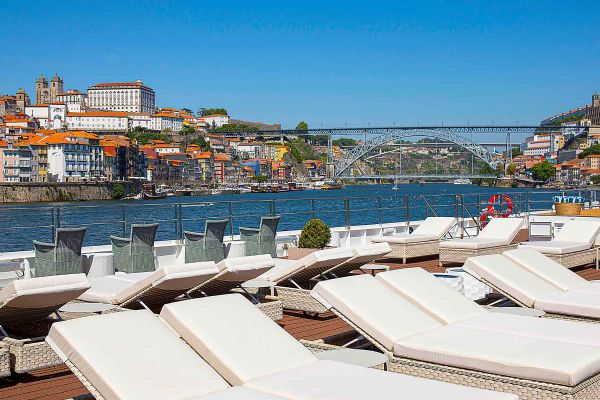 Deck of a river cruise ship lined with white recliner chairs